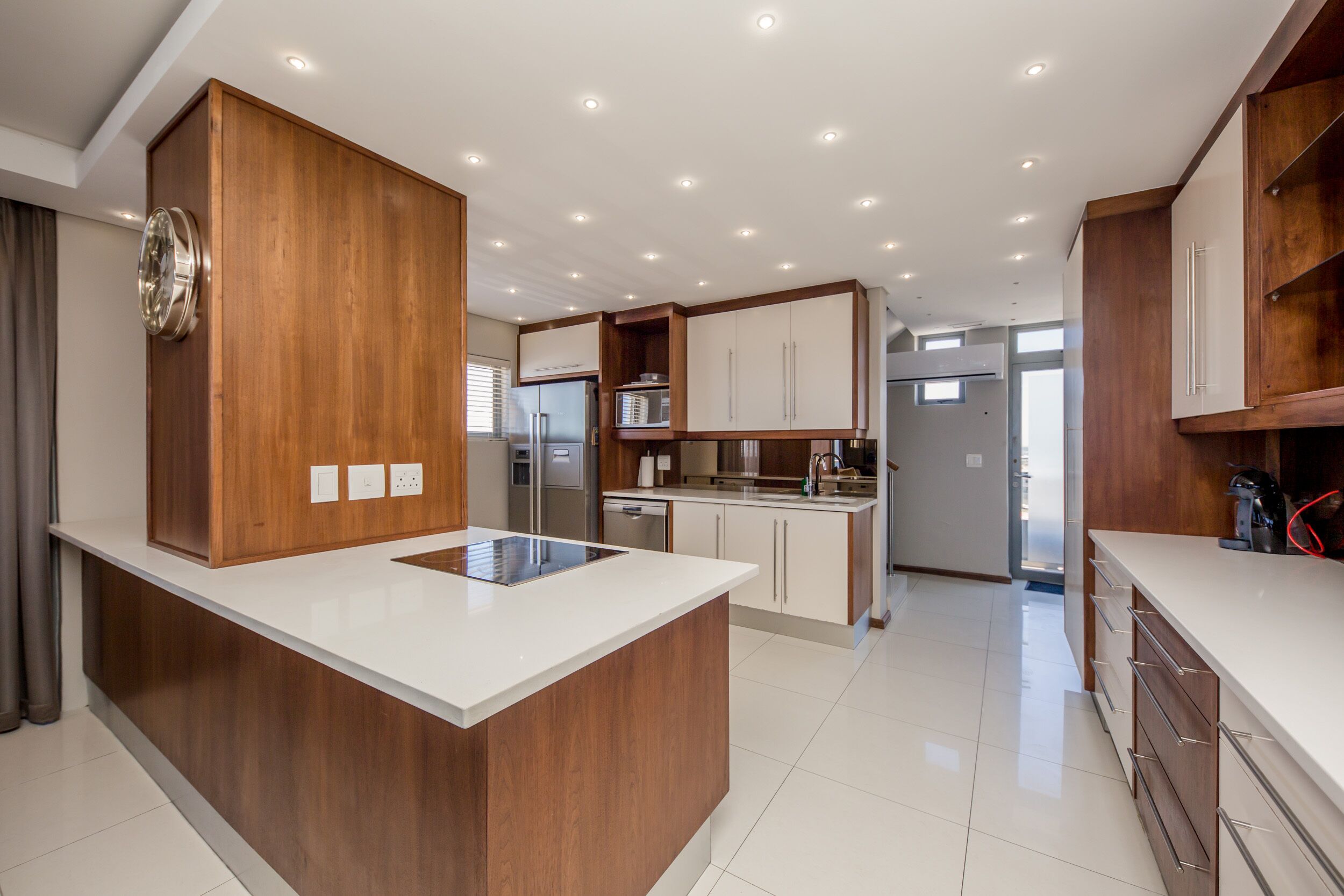 Een moderne keuken met houten kasten, een centraal eiland en geïntegreerde apparatuur.