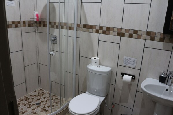 Un baño con ducha, inodoro y lavamanos.