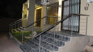 A modern building with a staircase leading to a door with a metal gate. - 85 Ehmke (Mbombela)