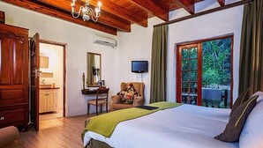 Une chambre à coucher avec un lit, un bureau avec une chaise, une télévision et une fenêtre avec des rideaux.