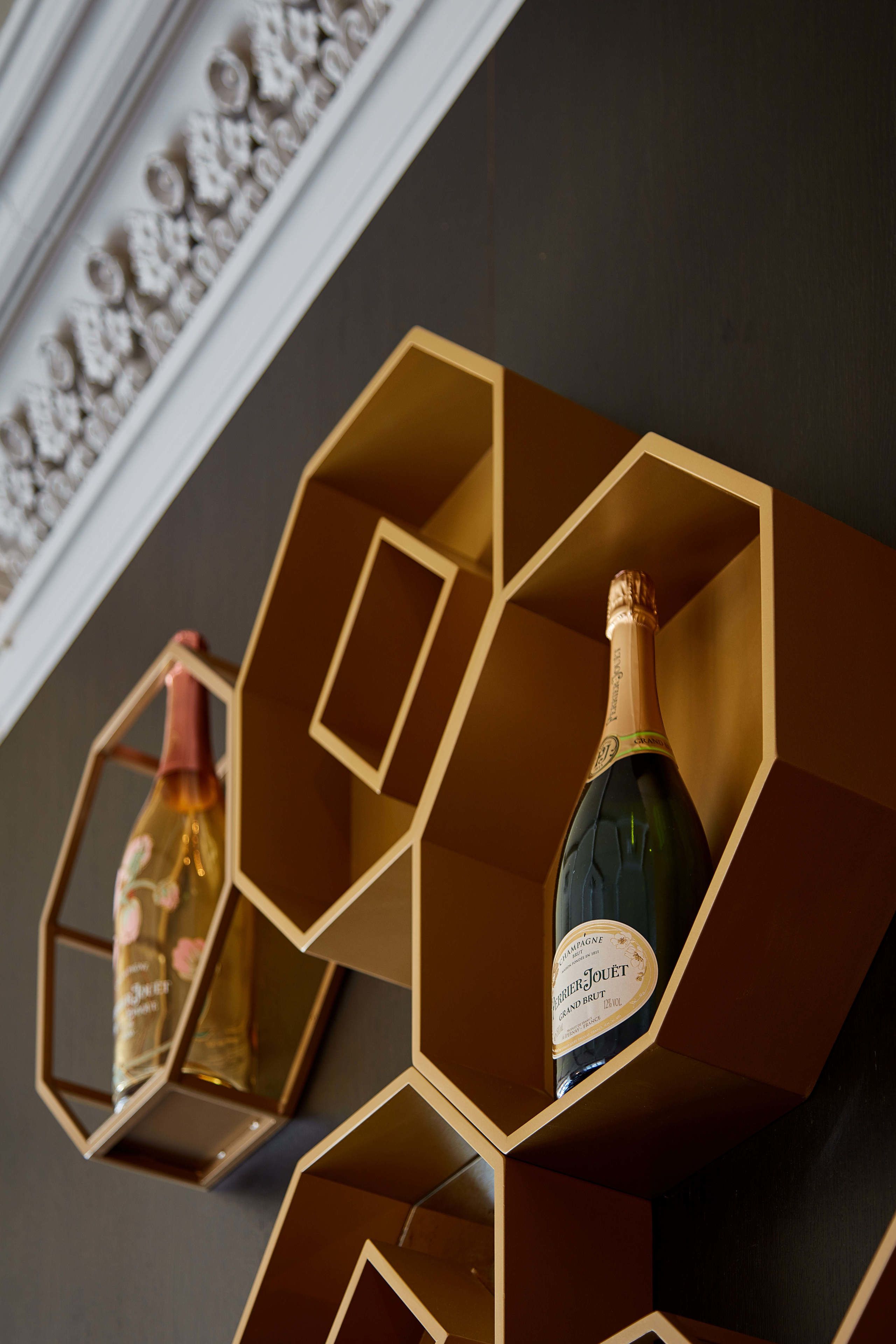 Two hexagonal shelves with bottles of champagne.