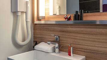 Ein modernes Badezimmer mit Waschbecken, Spiegel, Handtuch und Telefon.