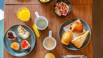 Ein Frühstückstisch mit Toast, Obst und einer Schüssel Müsli.