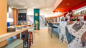 A restaurant with a bar area, seating, and a buffet. - ibis Styles Alès Centre Cévennes (Ales)