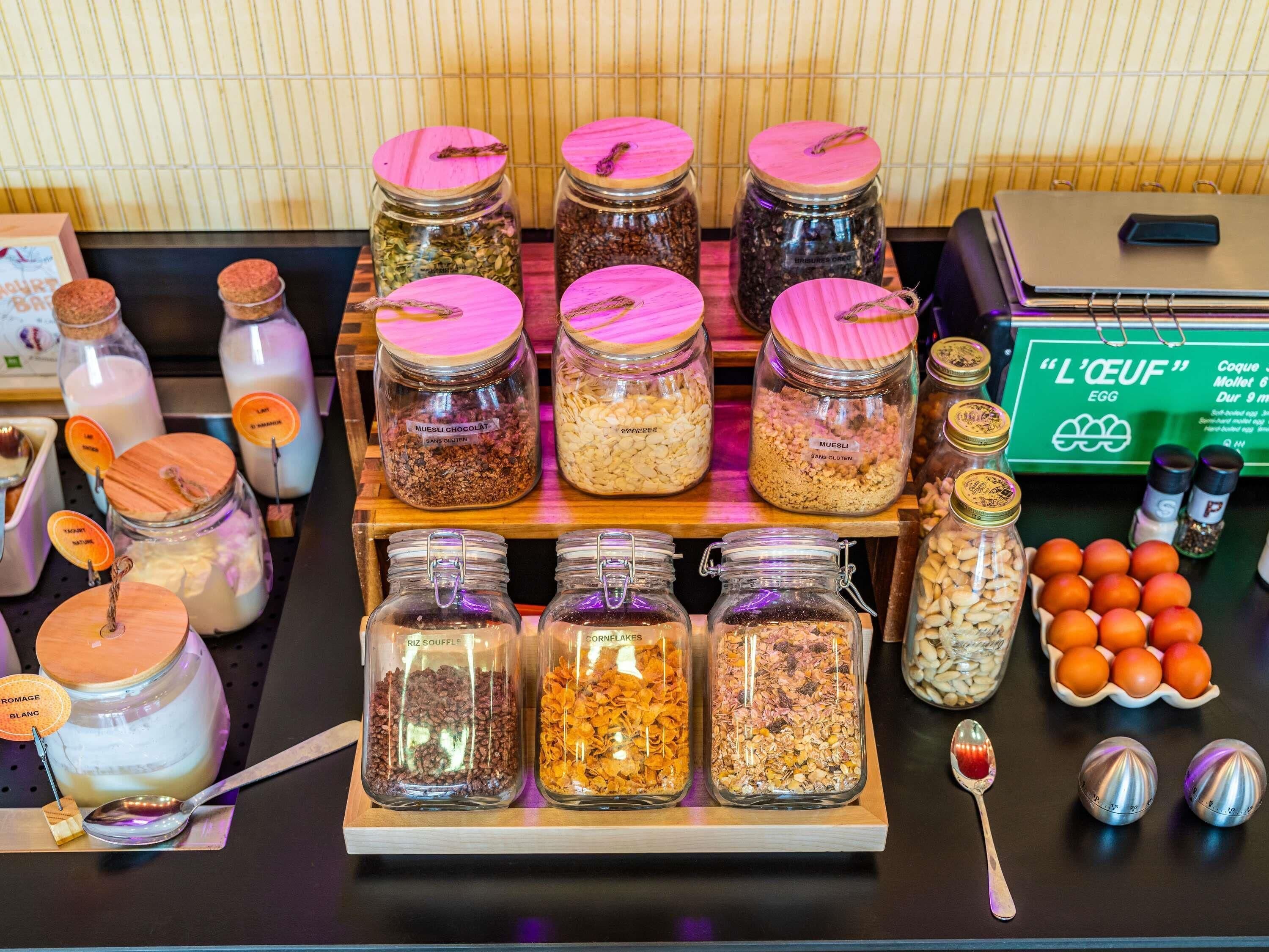 On peut voir une variété d’aliments en conserve dans des bocaux, dont certains sont étiquetés, ainsi qu’un plateau contenant d’autres bocaux.