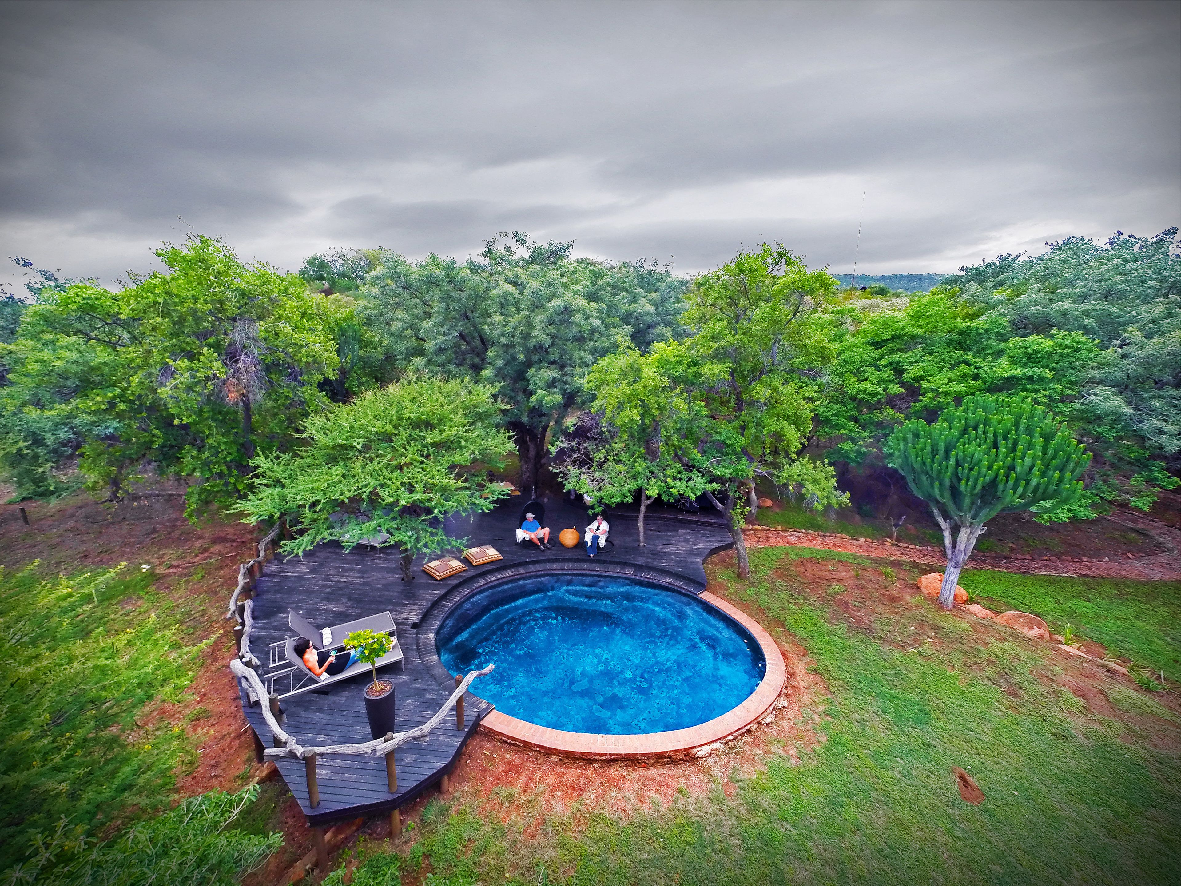 Une piscine extérieure dotée d’une terrasse en bois et de chaises longues.