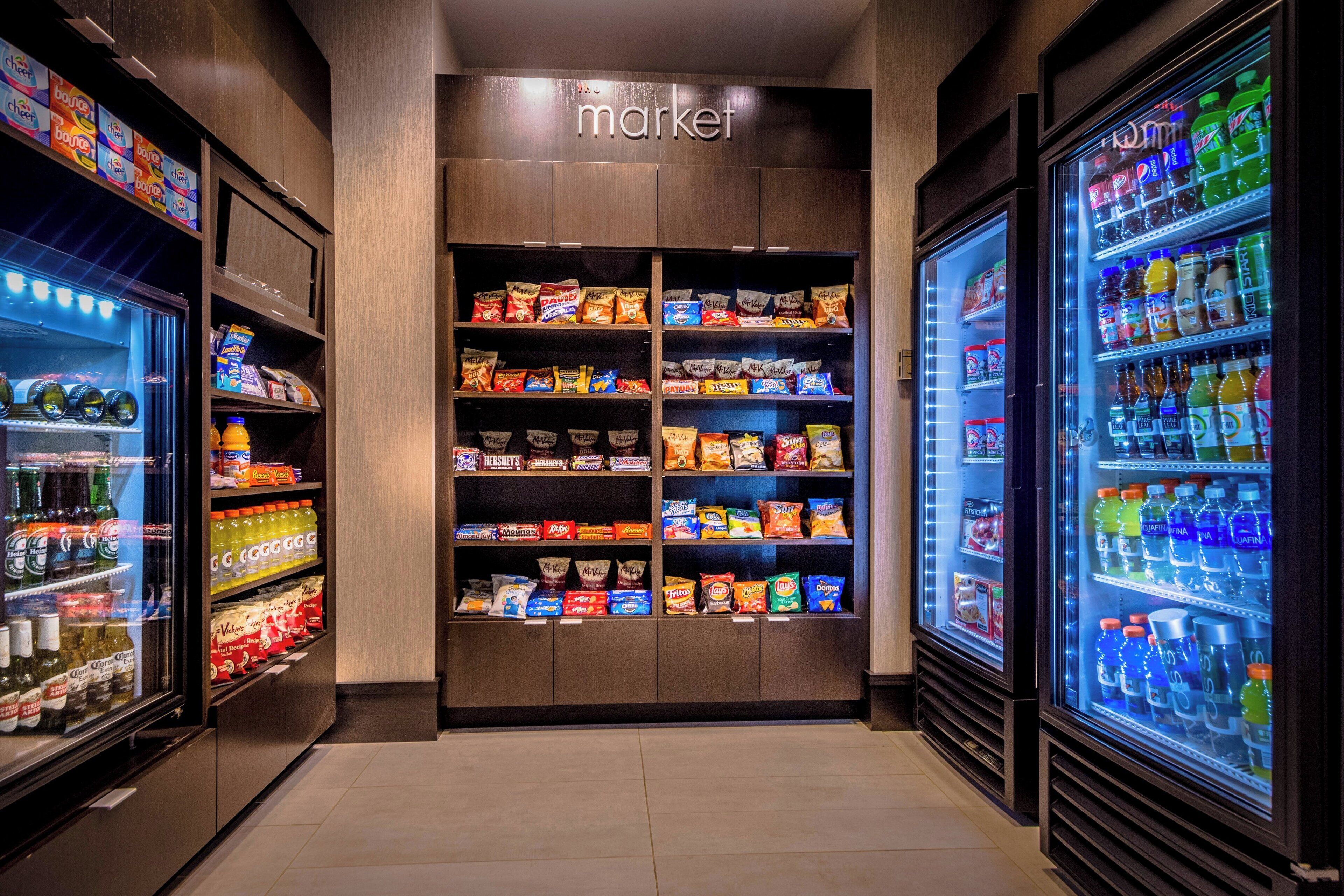 A snack and beverage vending area with multiple shelves stocked with various snacks and drinks.