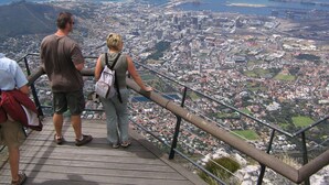 Une vue panoramique depuis un point d’observation élevé, donnant sur une ville côtière où se côtoient des immeubles résidentiels et des bâtiments commerciaux.