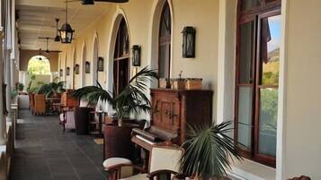 A corridor with arched ceilings, wooden furniture, and potted plants.