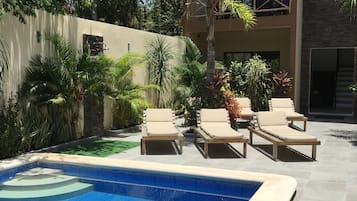 Alberca al aire libre y camastros