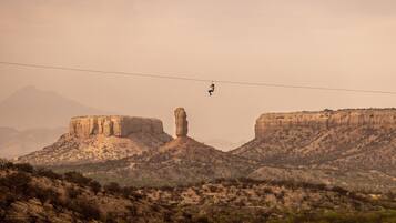 Una persona haciendo bungee jumping con un paisaje montañoso al fondo.
