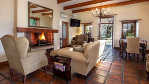 Una sala acogedora con chimenea, asientos cómodos y un comedor.