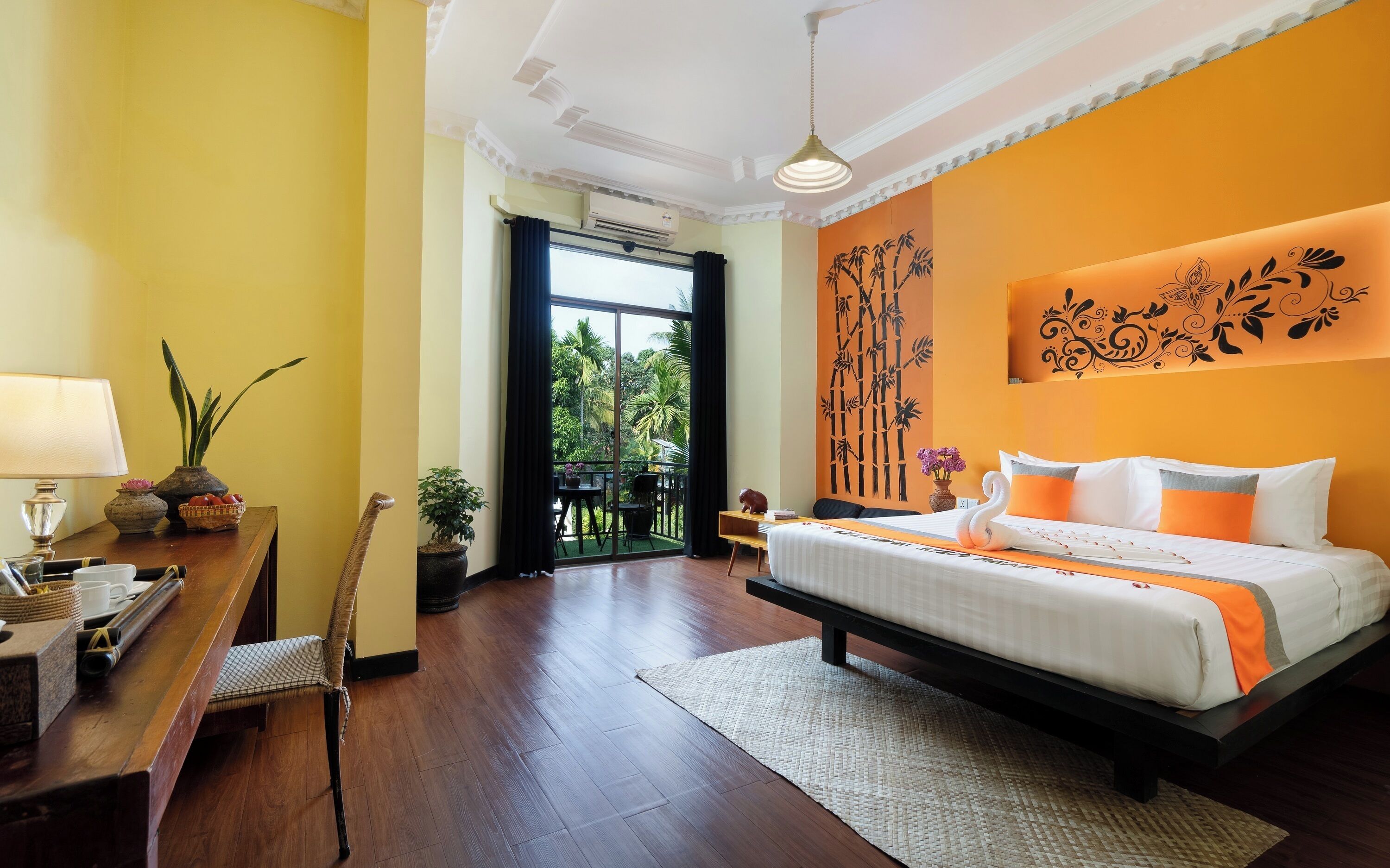 Une chambre d’hôtel comprenant un lit, un bureau, une chaise, une fenêtre et un balcon.