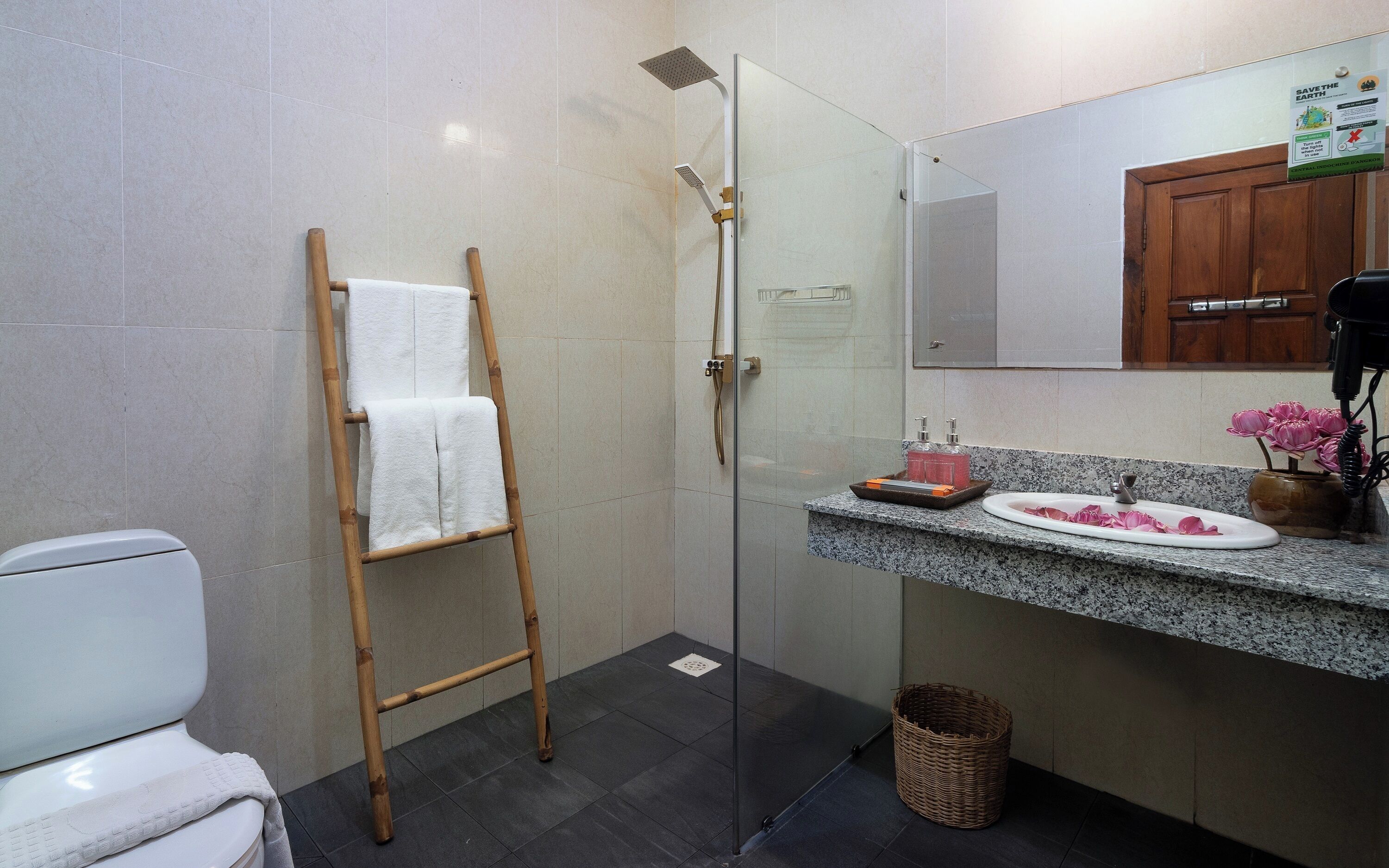 Een badkamer met douche, toilet en wastafel.