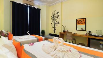 Una camera d'albergo con due letti, una scrivania, uno specchio e un elemento decorativo a parete.
