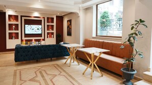 A modern hotel lobby with a seating area, a TV screen, and decorative shelves. - Reyyan Hotel (Istanbul)