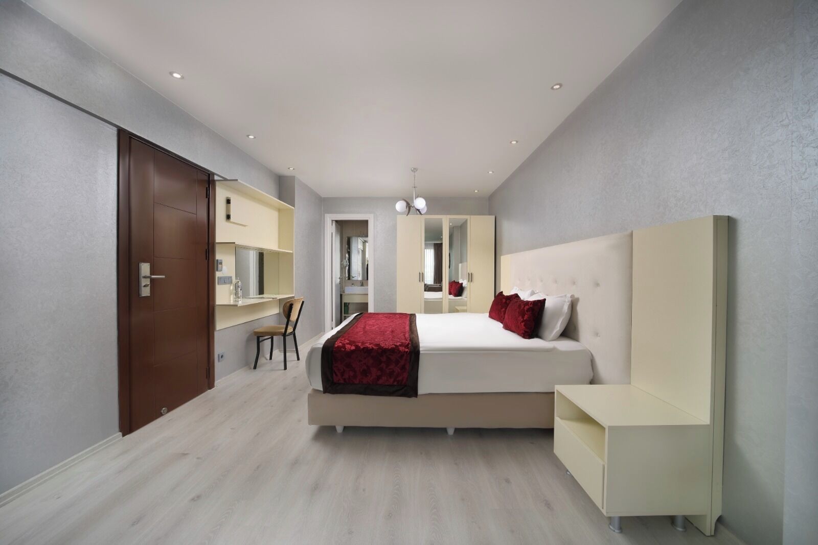 Un dormitorio moderno con una cama grande, un escritorio y un armario.