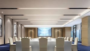 A conference room with a long table, chairs, and a large screen. - Novotel Ningbo East (Ningbo)
