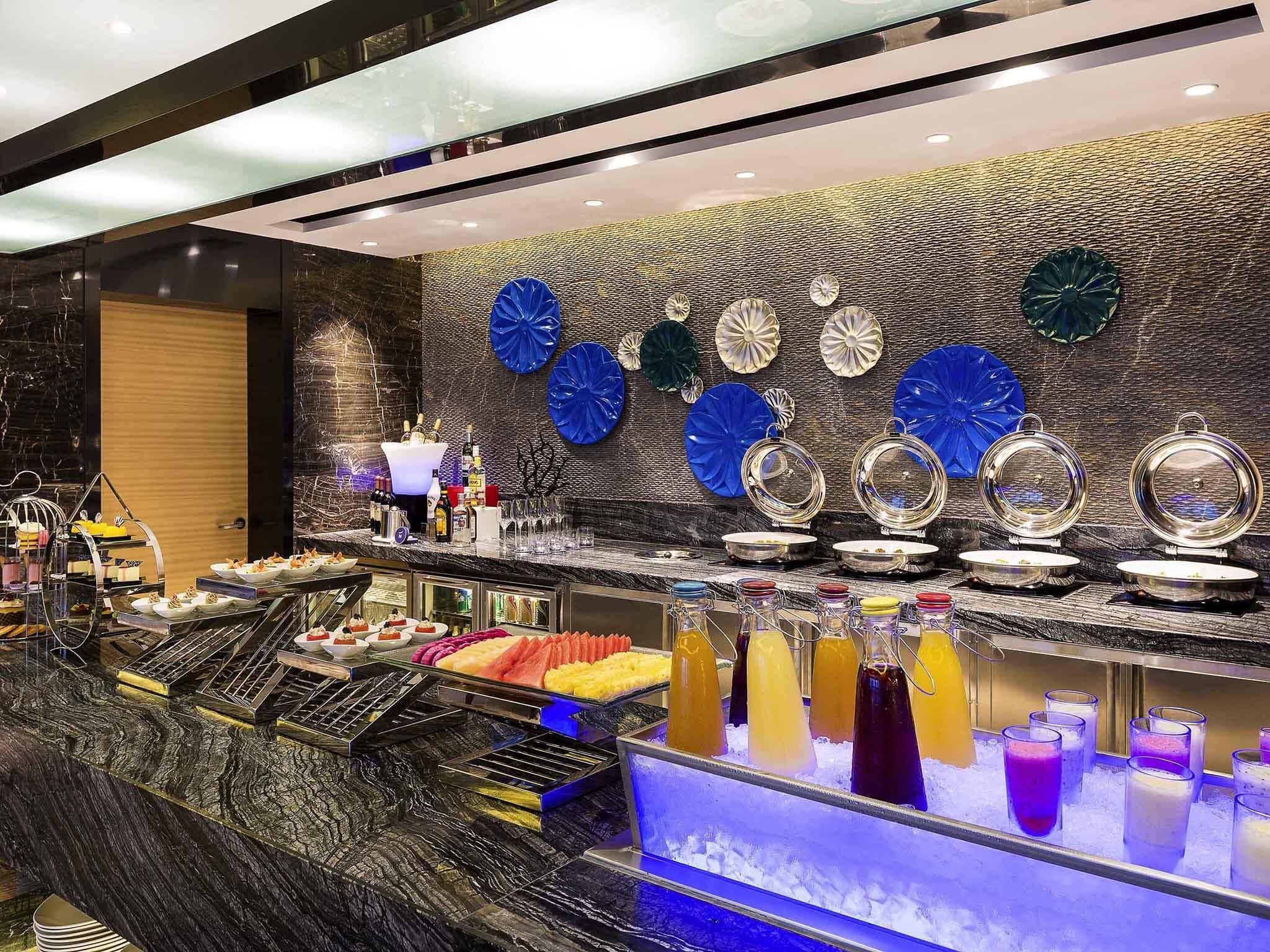 A bar area with a marble countertop, ice bins, and decorative wall art.
