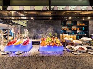 A buffet with various fruits and vegetables, a coffee station, and a selection of dishes. - Novotel Ningbo East (Ningbo)