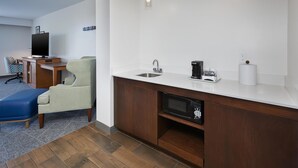 A modern kitchen with a built-in microwave, a sink, and a coffee maker.