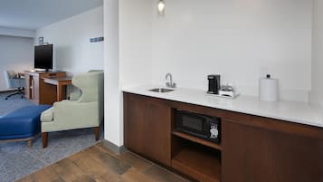 A modern kitchen with a built-in microwave, a sink, and a coffee maker.
