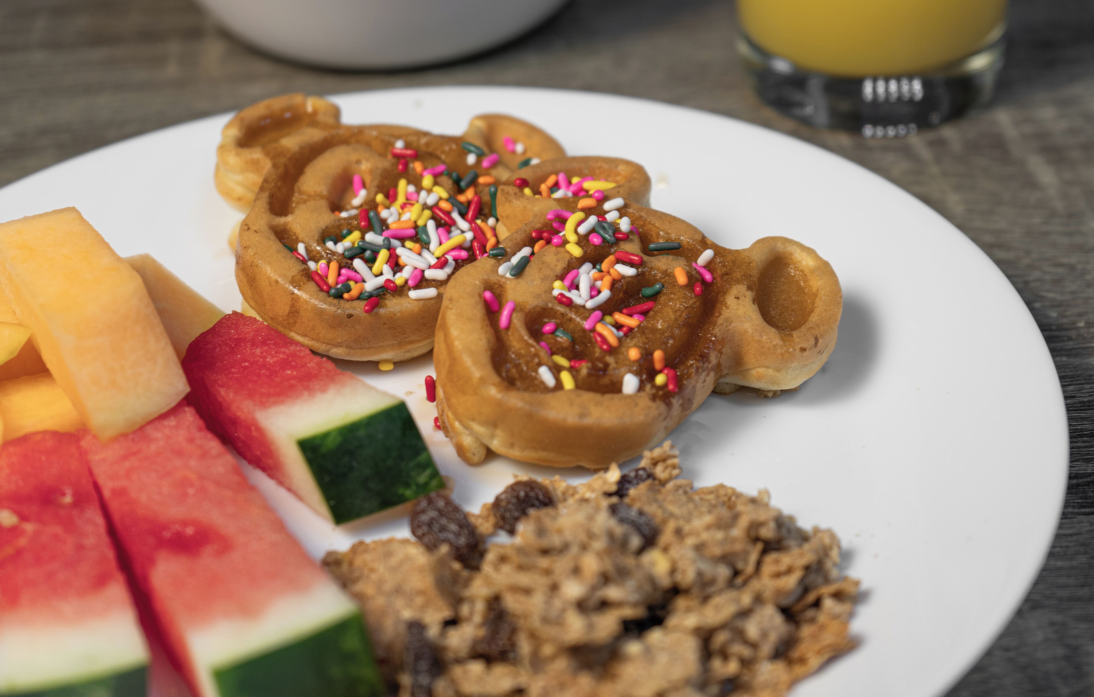 Une assiette avec des gaufres, de la pastèque et du granola.