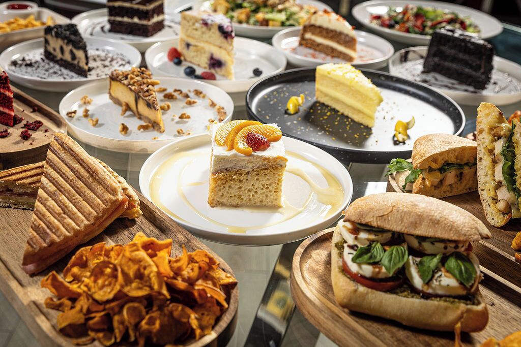 Diverse desserts en belegde broodjes staan opgesteld.