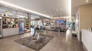 Un interno moderno con un negozio di souvenir, un'area salotto e una reception.