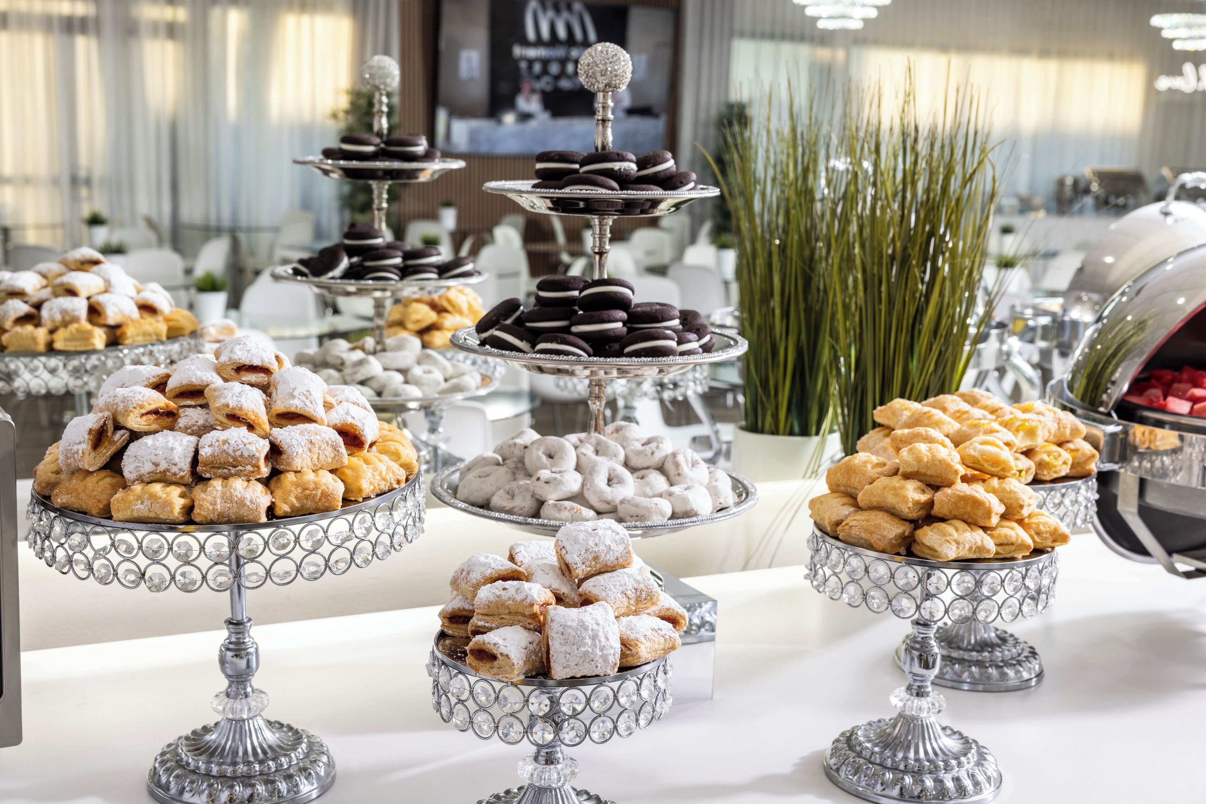 Un tavolo da buffet con diversi dessert su supporti d'argento.
