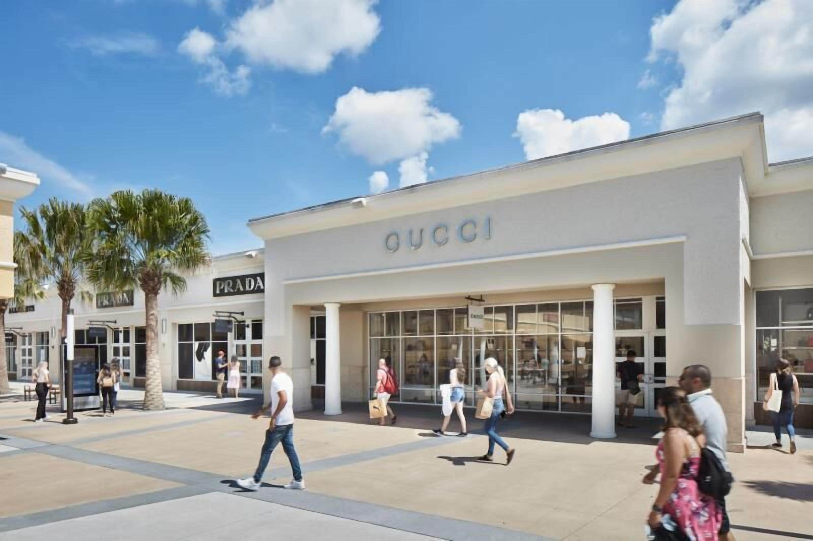 A shopping area with storefronts including Gucci and Prada.