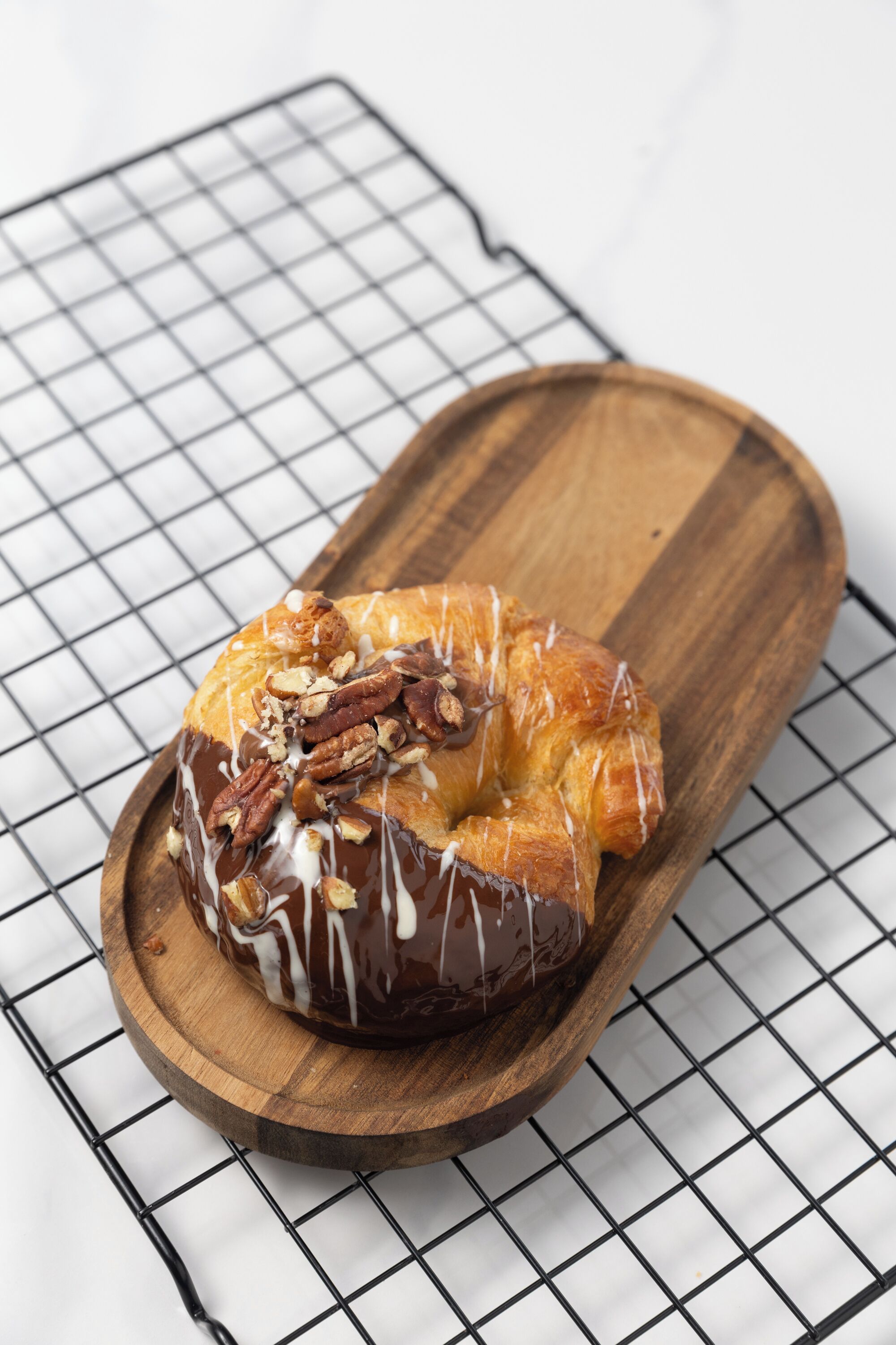 Un pastel glaseado de chocolate sobre una tabla de madera.