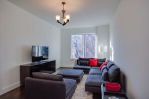 Apartamento superluxo, 2 quartos | Sala de estar | TV de tela plana