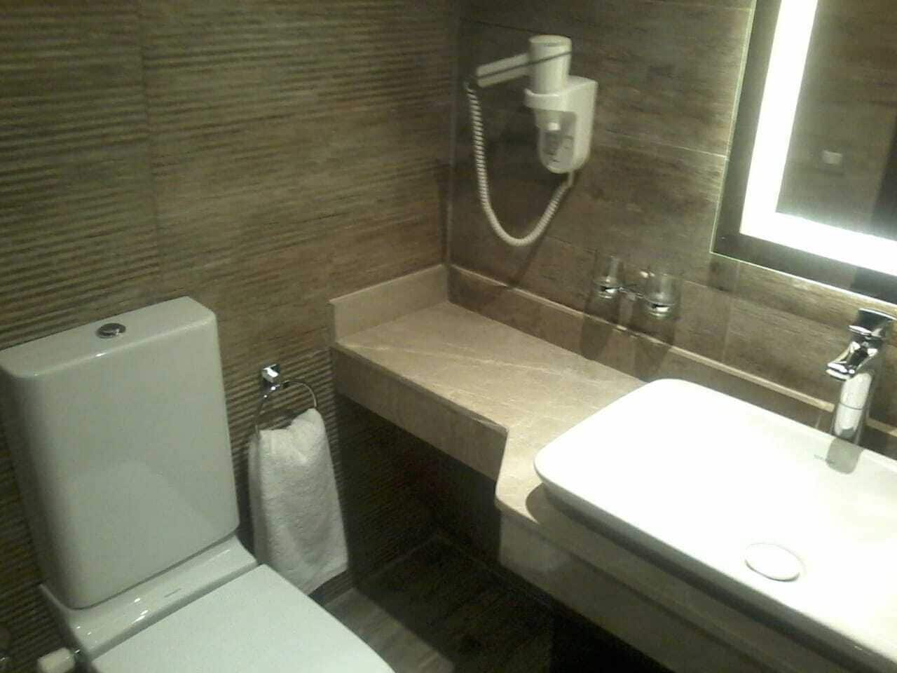 A bathroom with a toilet, a sink, and a shower.