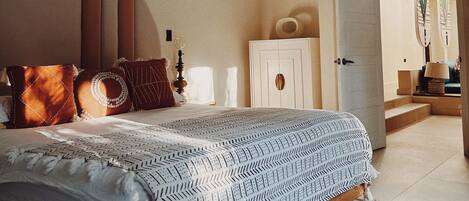 Un dormitorio con una cama grande, un armario y una cesta colgante.