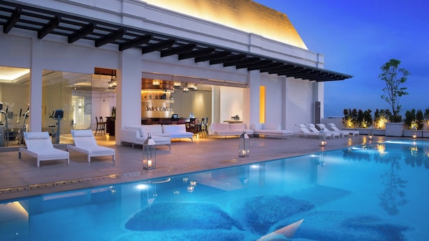 Un área de piscina moderna con sillones de descanso y una zona de bar.