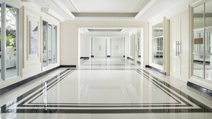 Un largo pasillo pulido con puertas de cristal y una vista despejada al exterior.