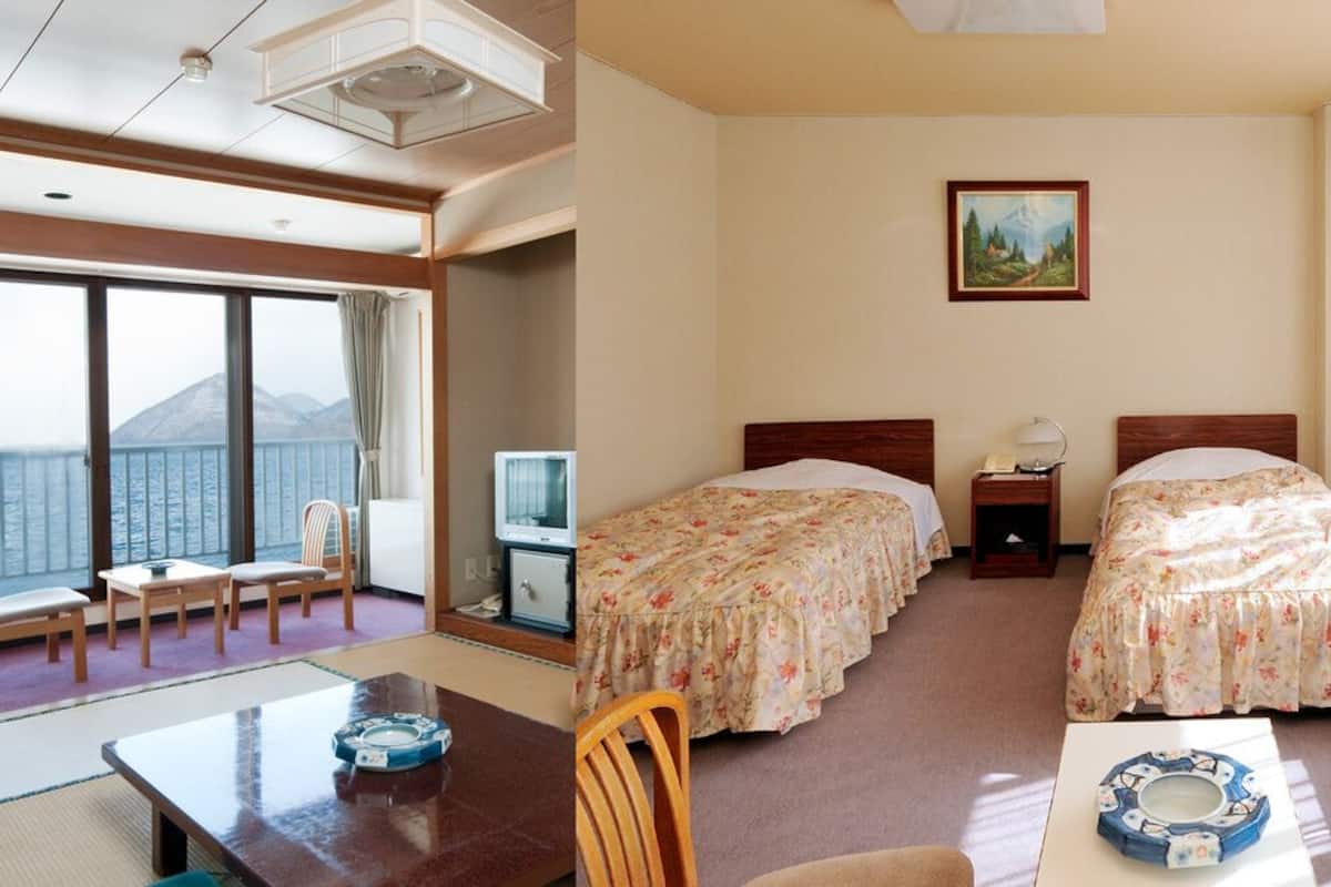 A room with a large window, a bed, a desk, and a chair.
