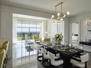 A spacious dining area with a large table, chairs, and a chandelier. - Mövenpick Resort Khao Yai (Pak Chong)