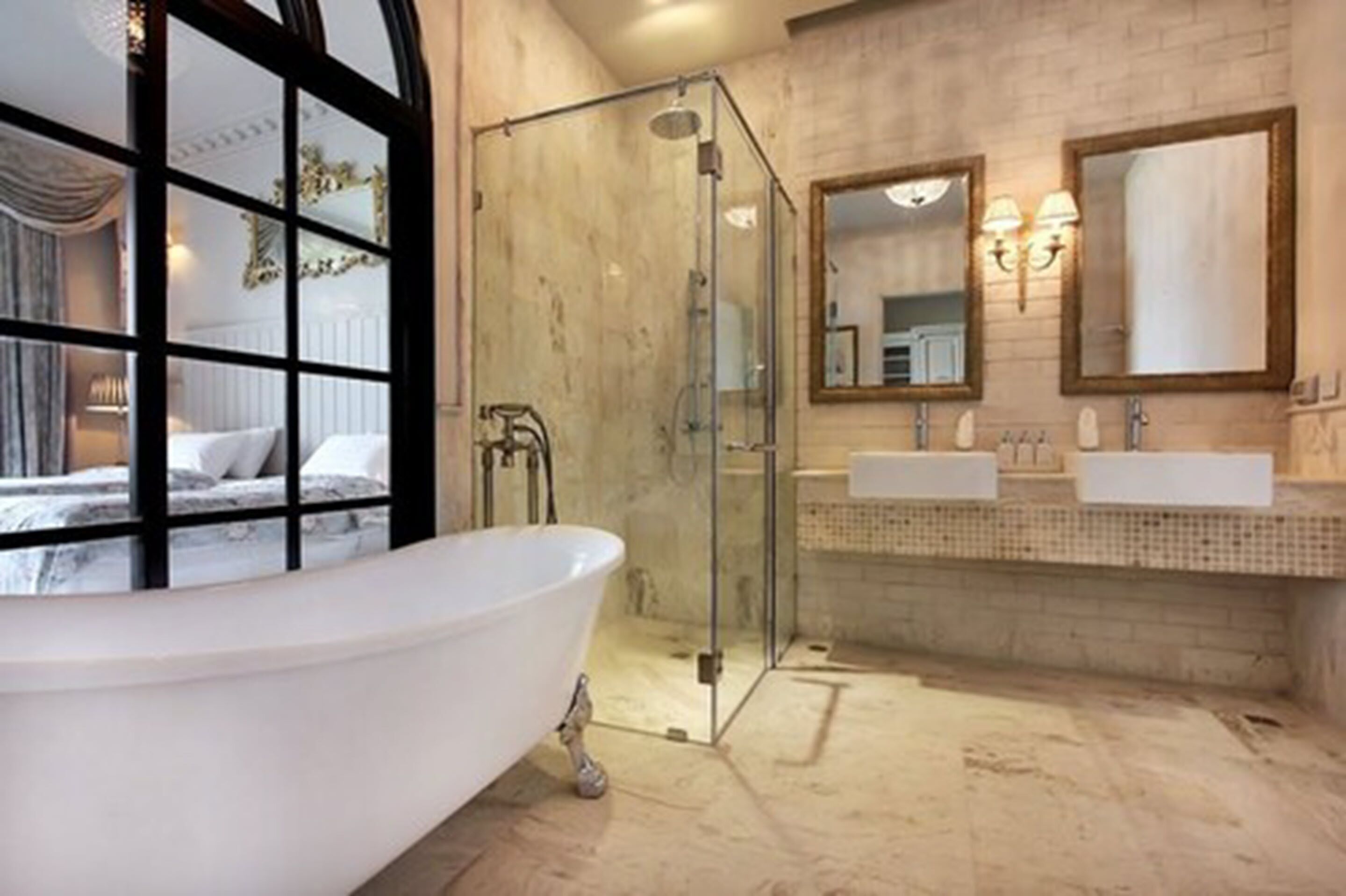 A bathroom with a freestanding bathtub, a glass-enclosed shower, and a double sink vanity.