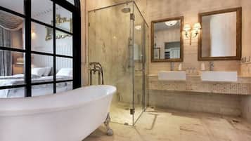 A bathroom with a freestanding bathtub, a glass-enclosed shower, and a double sink vanity.