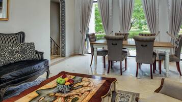 A dining area with a table and chairs, a sofa, and a decorative rug.