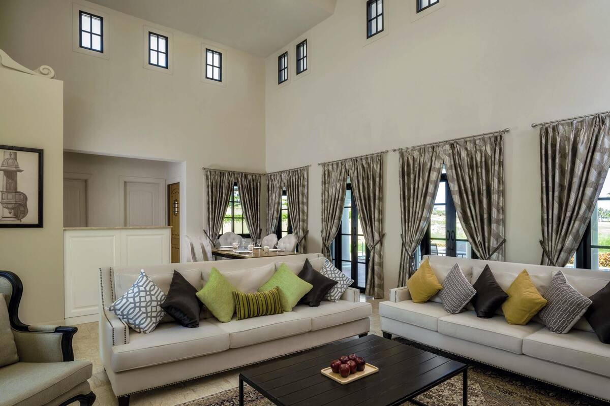 A spacious living room with two sofas, a coffee table, and a dining area with a table and chairs.