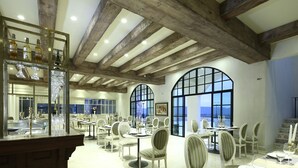 A restaurant with wooden beams, large windows, and tables set for dining. - Mövenpick Resort Khao Yai (Pak Chong)