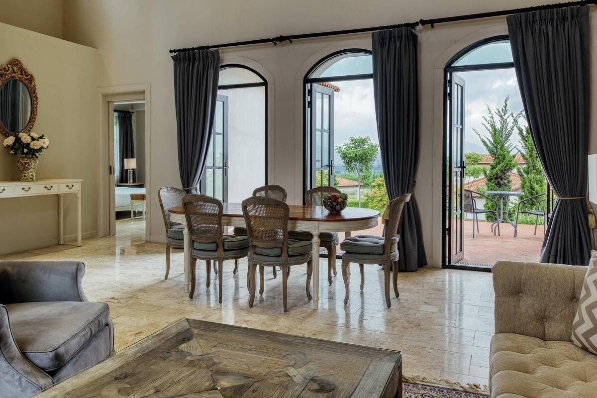 A spacious living room with a dining area, large windows, and a view of the outdoors.