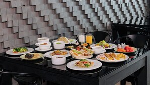 A dining table with various dishes and a glass of orange juice. - The Core Gallery Hotel (Chiang Mai)