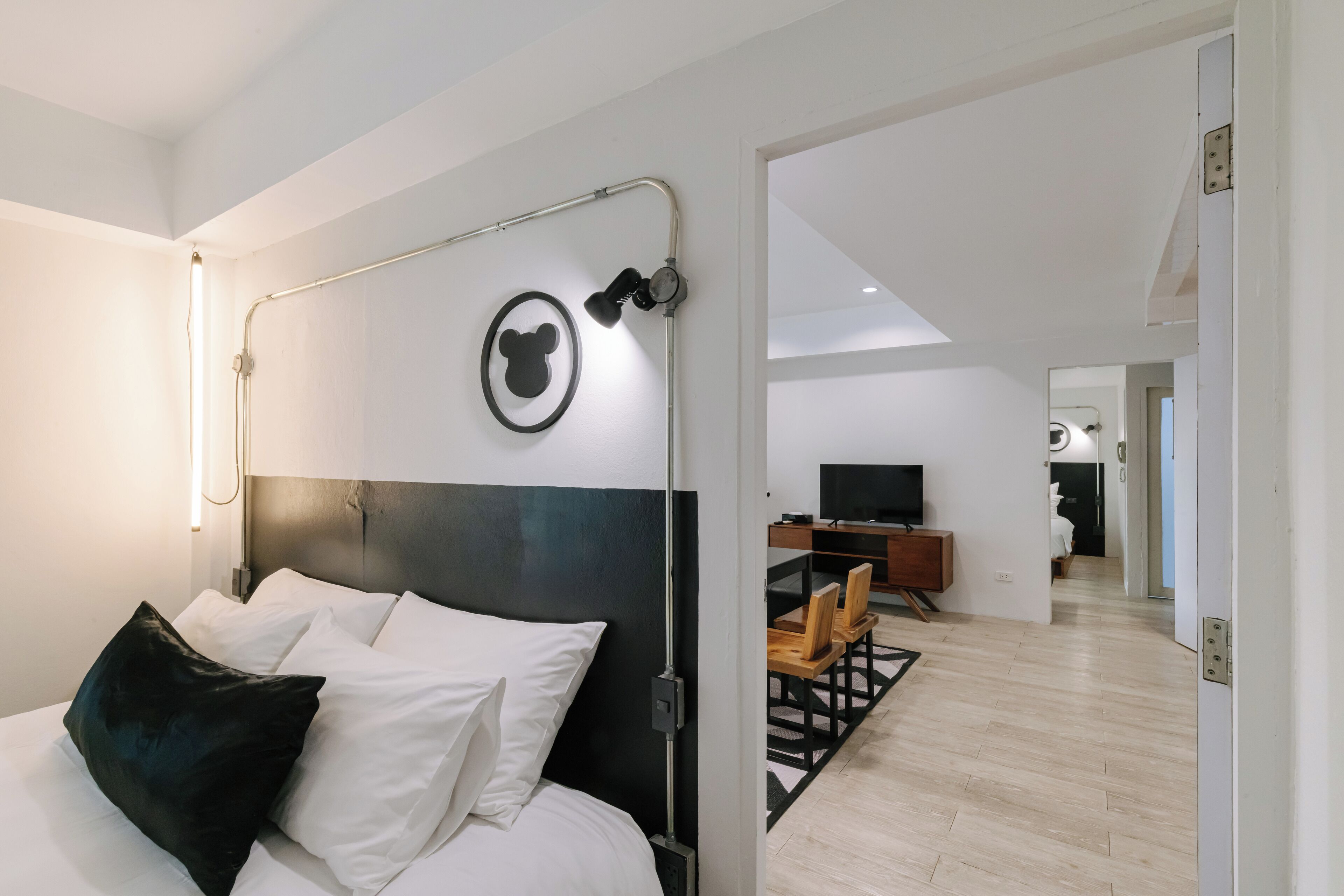 Une chambre d’hôtel moderne équipée d’un lit, d’un bureau et d’une télévision.