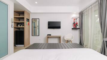 Une chambre d’hôtel moderne équipée d’un lit, d’une télévision, d’un bureau, d’une chaise, d’une armoire et d’une fenêtre avec des rideaux.