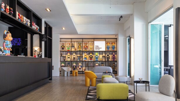 A hotel lobby with a reception desk, colorful plush toys, a large display of figurines, and modern seating. - The Core Gallery Hotel (Chiang Mai)