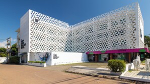A modern hotel with a distinctive geometric facade and a visible entrance. - The Core Gallery Hotel (Chiang Mai)